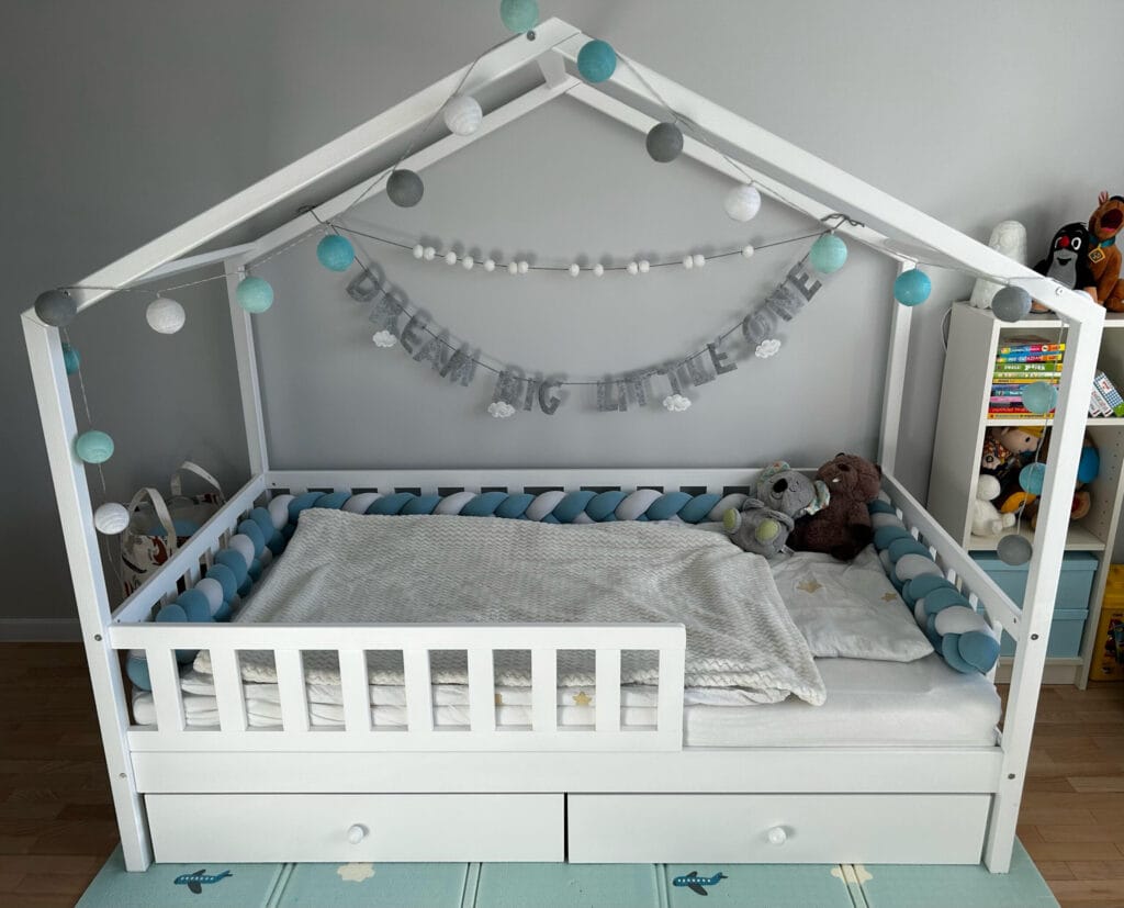 Łóżko dla dwulatka w kolorze białym z podwójnymi szufladami.