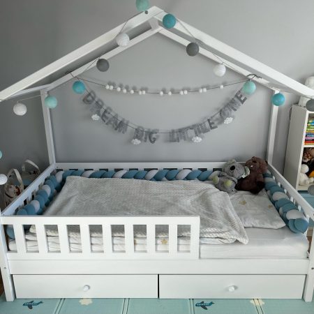 Łóżko dla dwulatka w kolorze białym z podwójnymi szufladami.