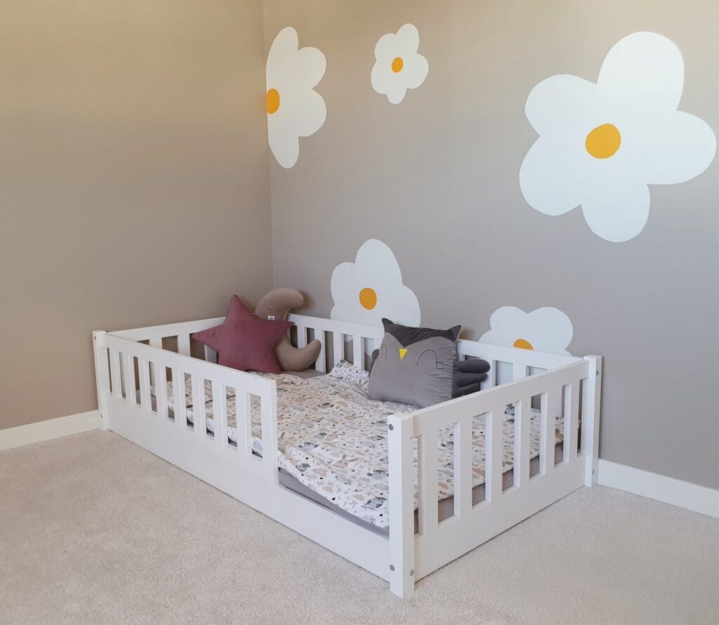 Klasyczne łóżko dziecięce z barierkami dla dzieci w kolorze białym.
