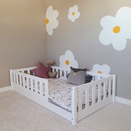 Klasyczne łóżko dziecięce z barierkami dla dzieci w kolorze białym.