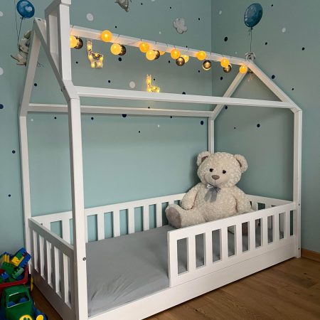 Łóżko domek z barierkami, białe, bez szuflad dla dzieci.