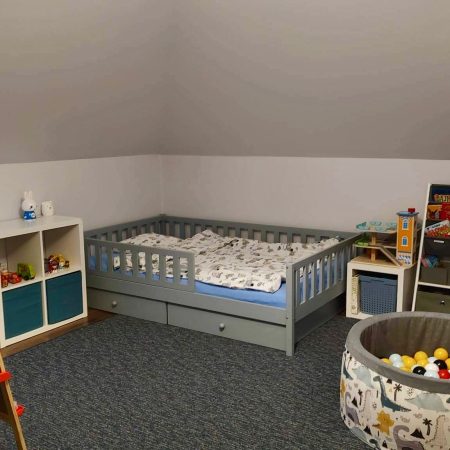 Łóżka dla dzieci w kształcie domku w aranżacji w dziecięcym pokoju.