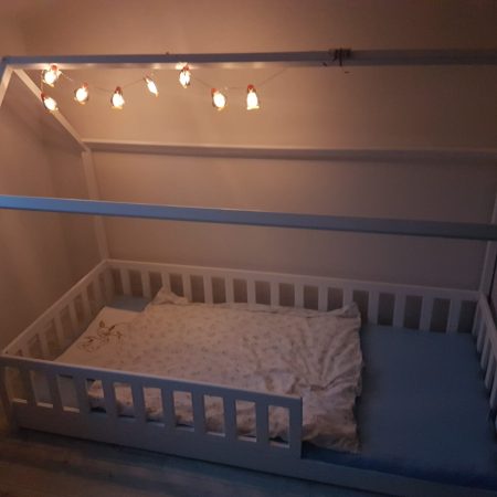 Łóżka dla dzieci w kształcie domku w aranżacji w dziecięcym pokoju.