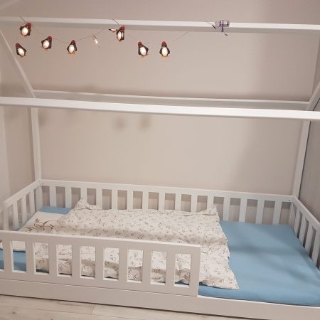 Łóżka dla dzieci w kształcie domku w aranżacji w dziecięcym pokoju.