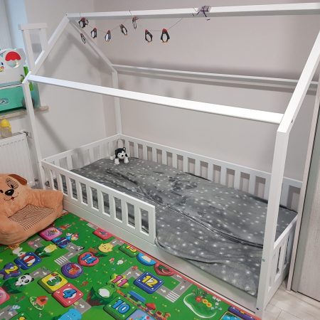 Łóżka dla dzieci w kształcie domku w aranżacji w dziecięcym pokoju.