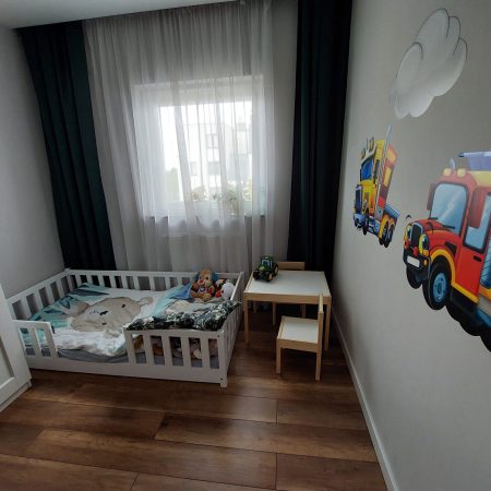 Łóżka dla dzieci w kształcie domku w aranżacji w dziecięcym pokoju.