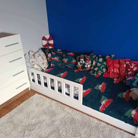 Klasyczne białe łóżko ze zdejmowaną barierką dla dzieci.